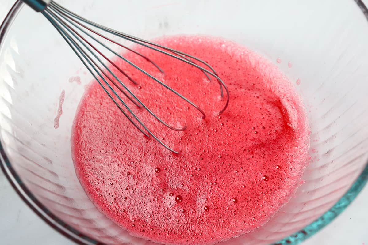 dissolving strawberry jello in glass bowl