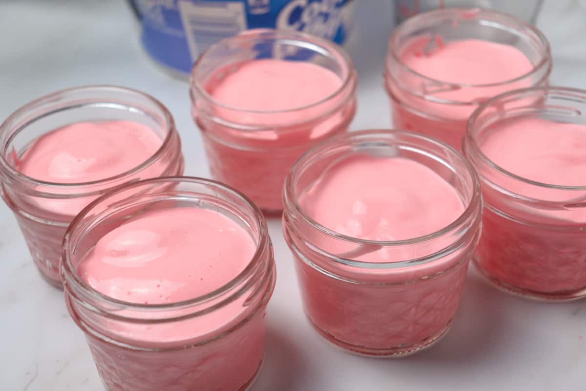 pouring sugar free strawberry fluff into jars