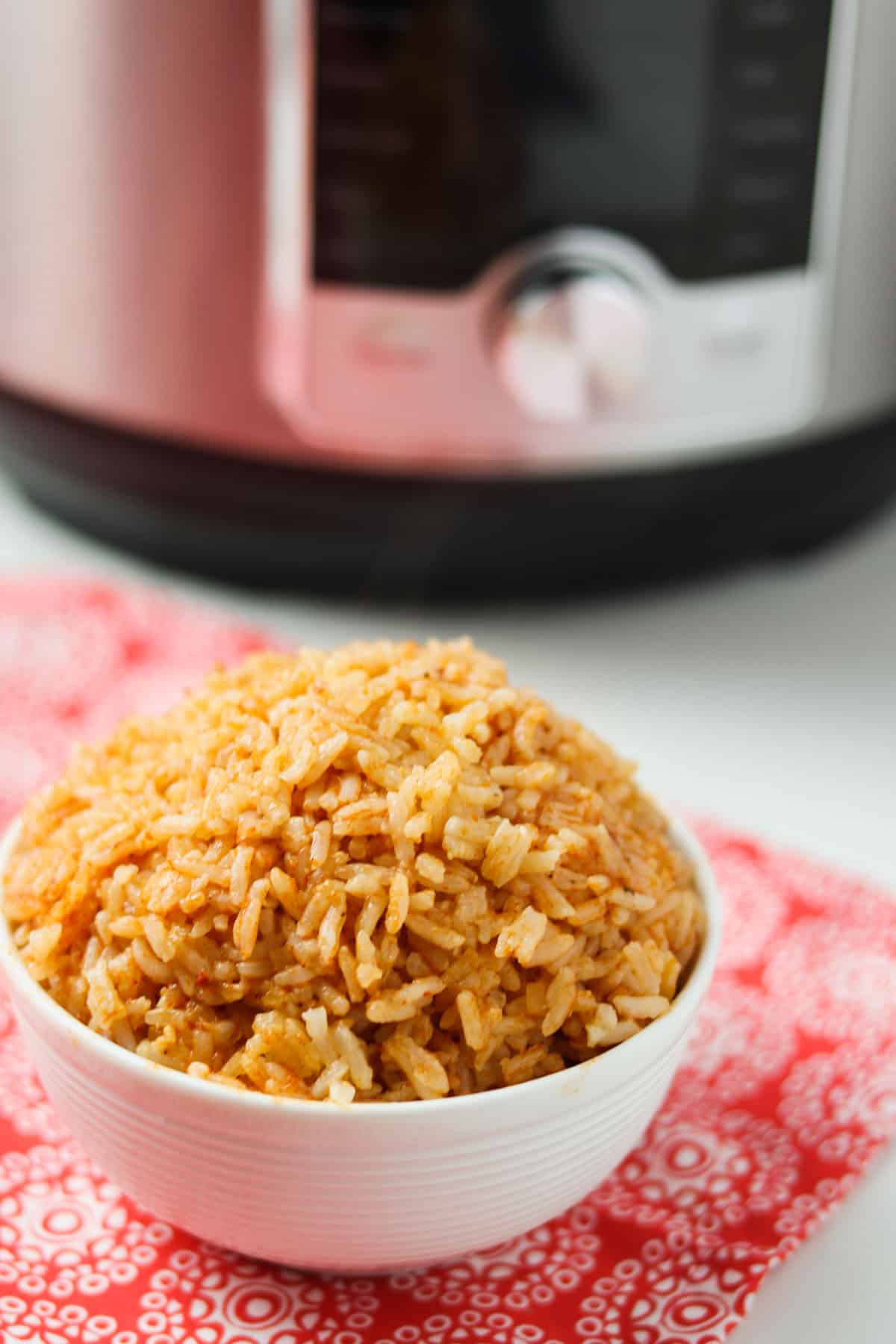 instant pot mexican rice in white bowl with instant pot in background