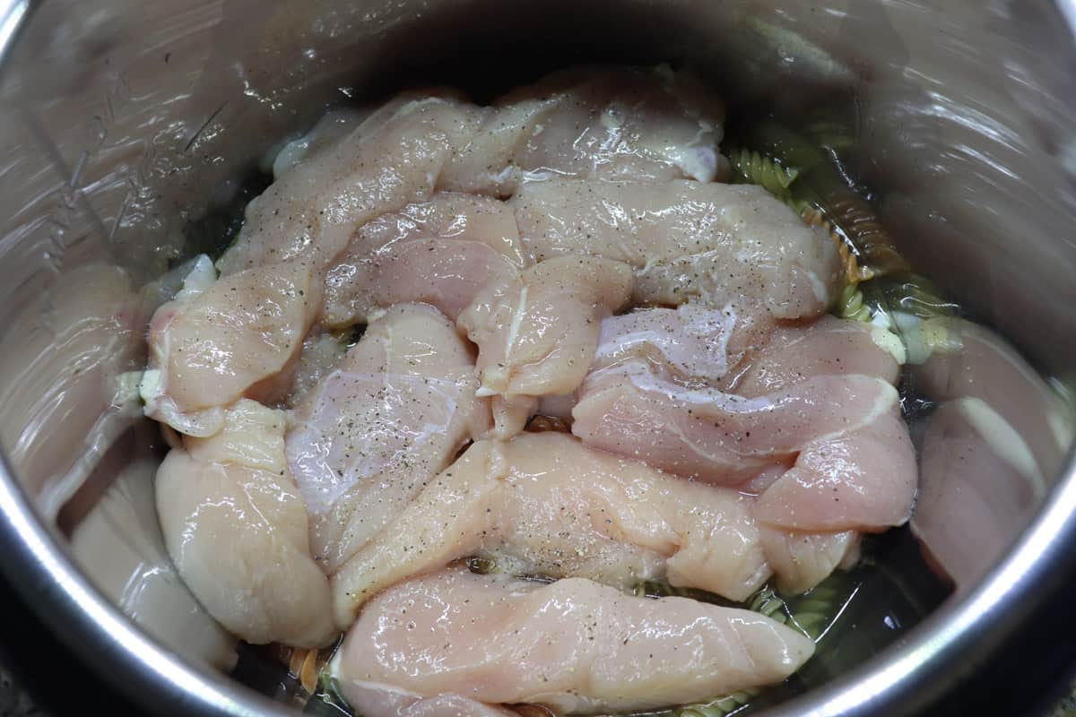 layering raw chicken tenders on top of pasta in instant pot