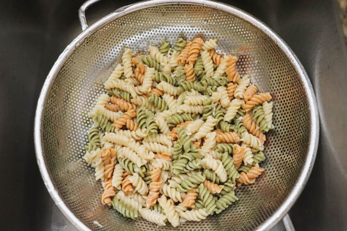 Rinsing rotini noodles with cold water