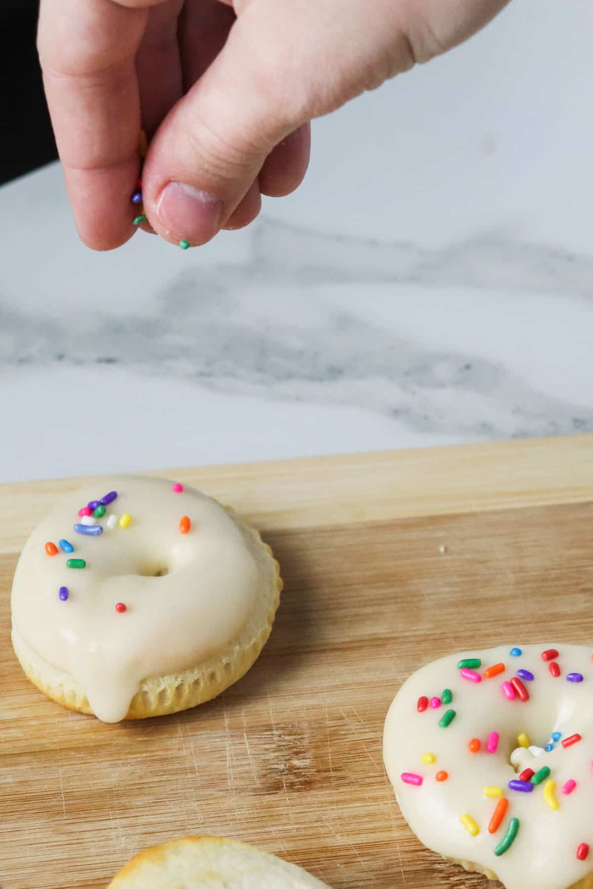 putting sprinkles on donuts