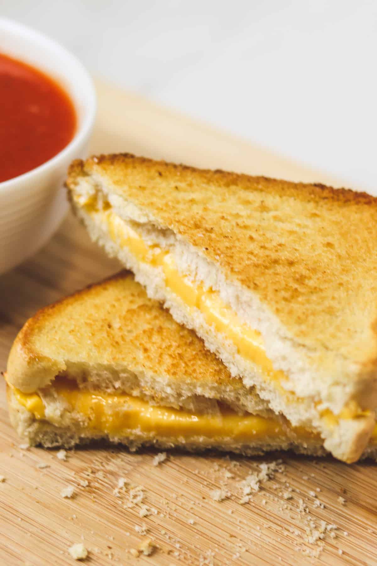 stacked grilled cheese on a wood cutting board