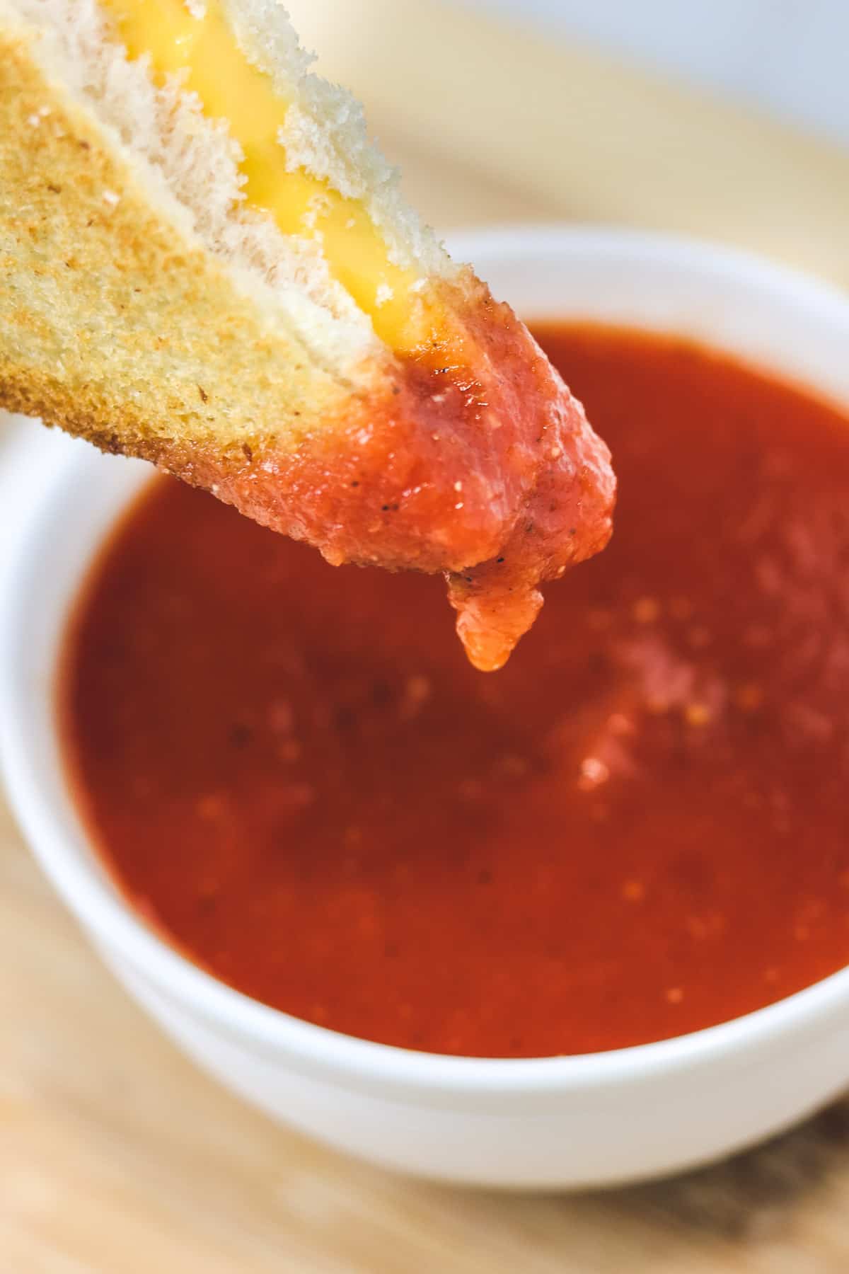 dipping a grilled cheese in tomato soup