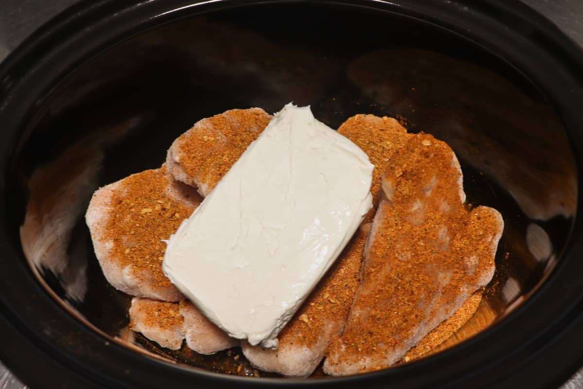 frozen chicken breasts, taco seasoning, and cream cheese in crock pot