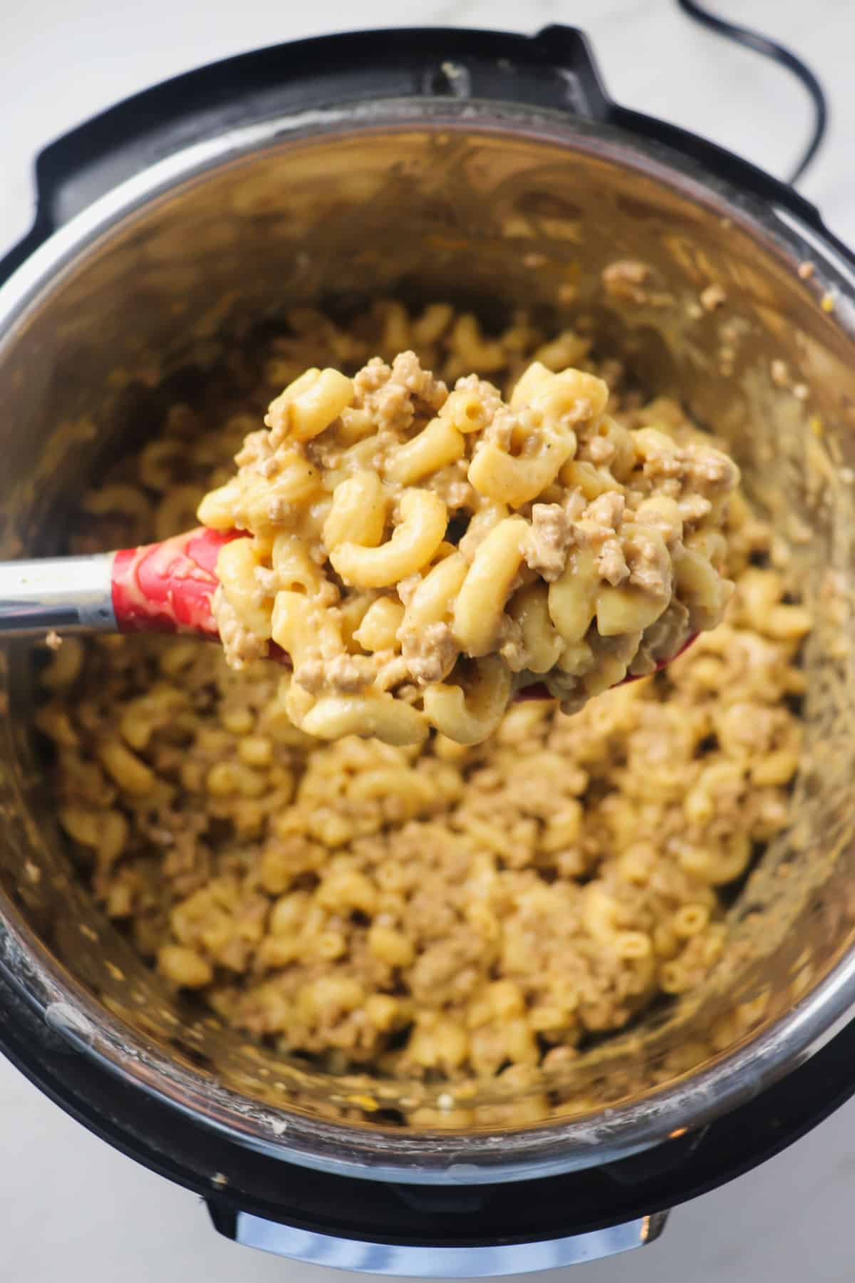 scooping out a spoonful of cheeseburger macaroni out of the instant pot