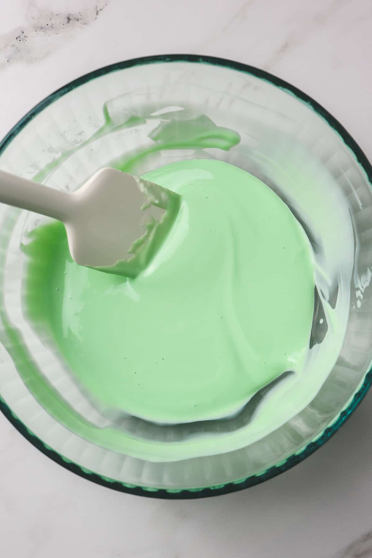 lime jello mixed with key lime pie yogurt in glass mixing bowl
