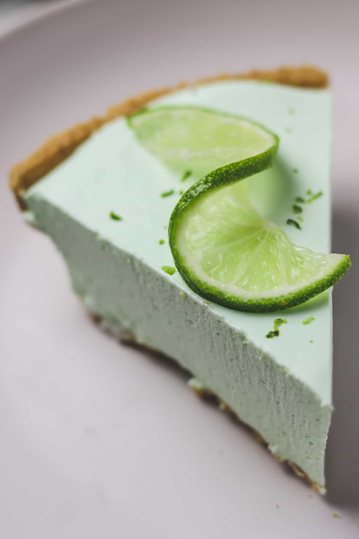 single piece of no-bake key lime pie with lime zest and a lime twist garnish