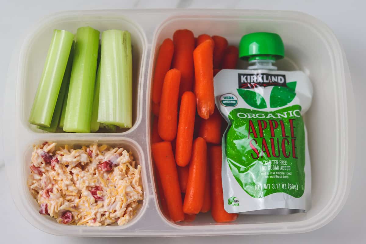 pimento cheese, carrots, celery, and apple sauce in a divided lunch container