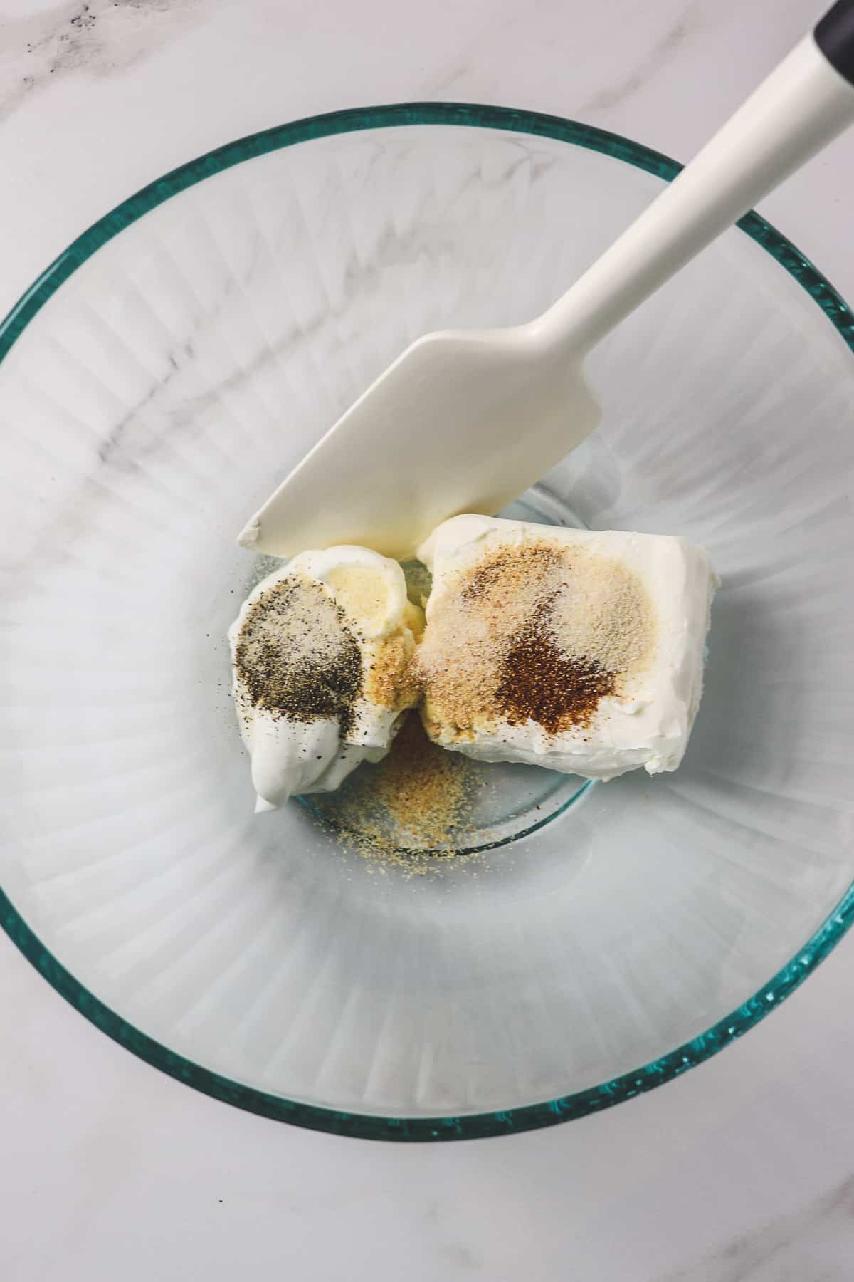 cream cheese, sour cream, and seasonings in glass bowl