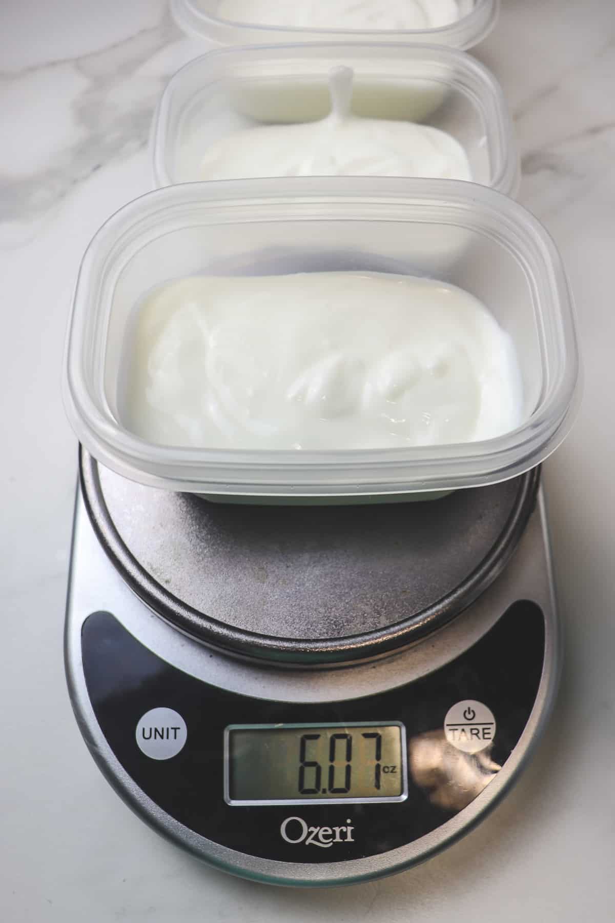 measuring yogurt portions into small plastic containers