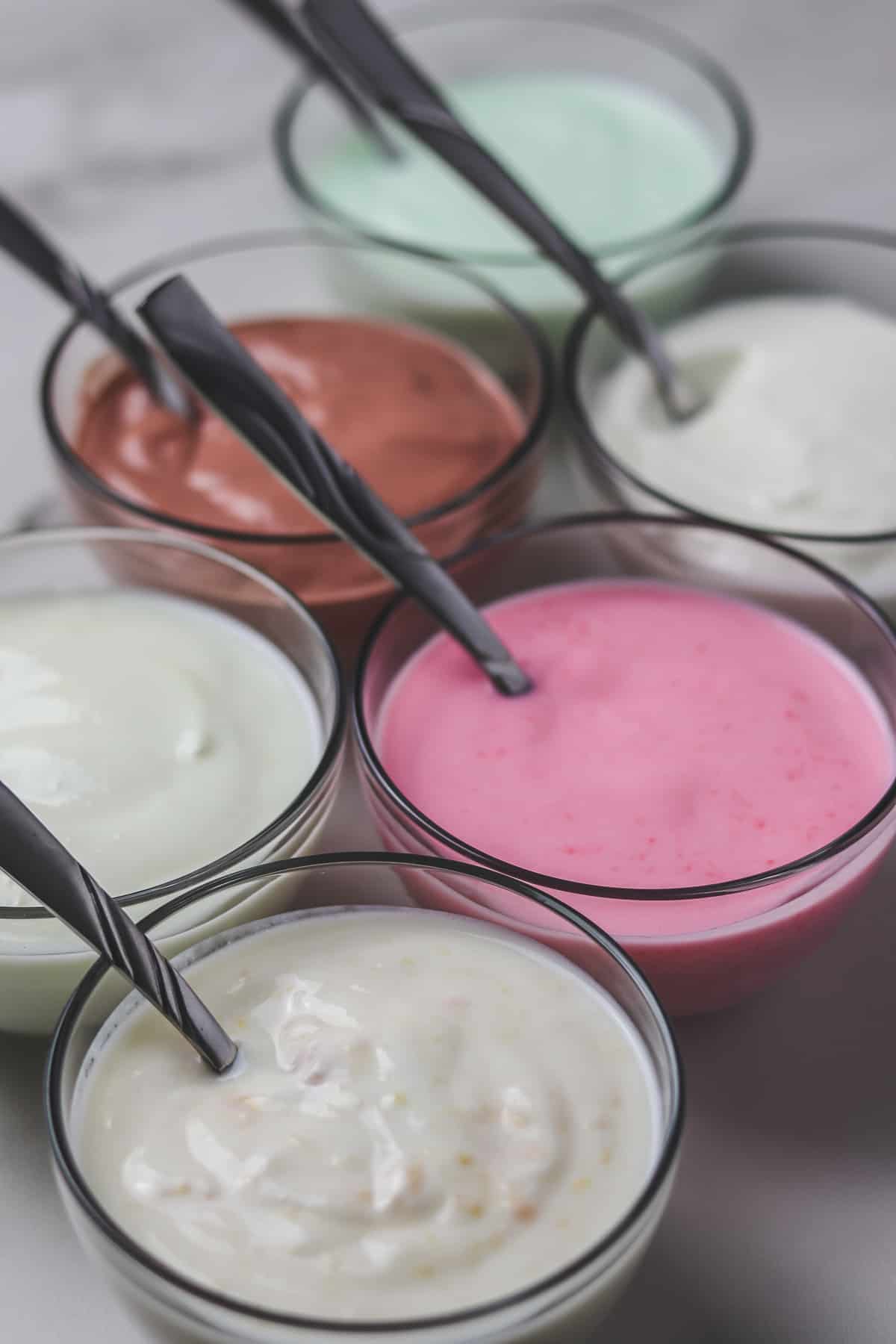 small glass bowls of different flavored yogurt