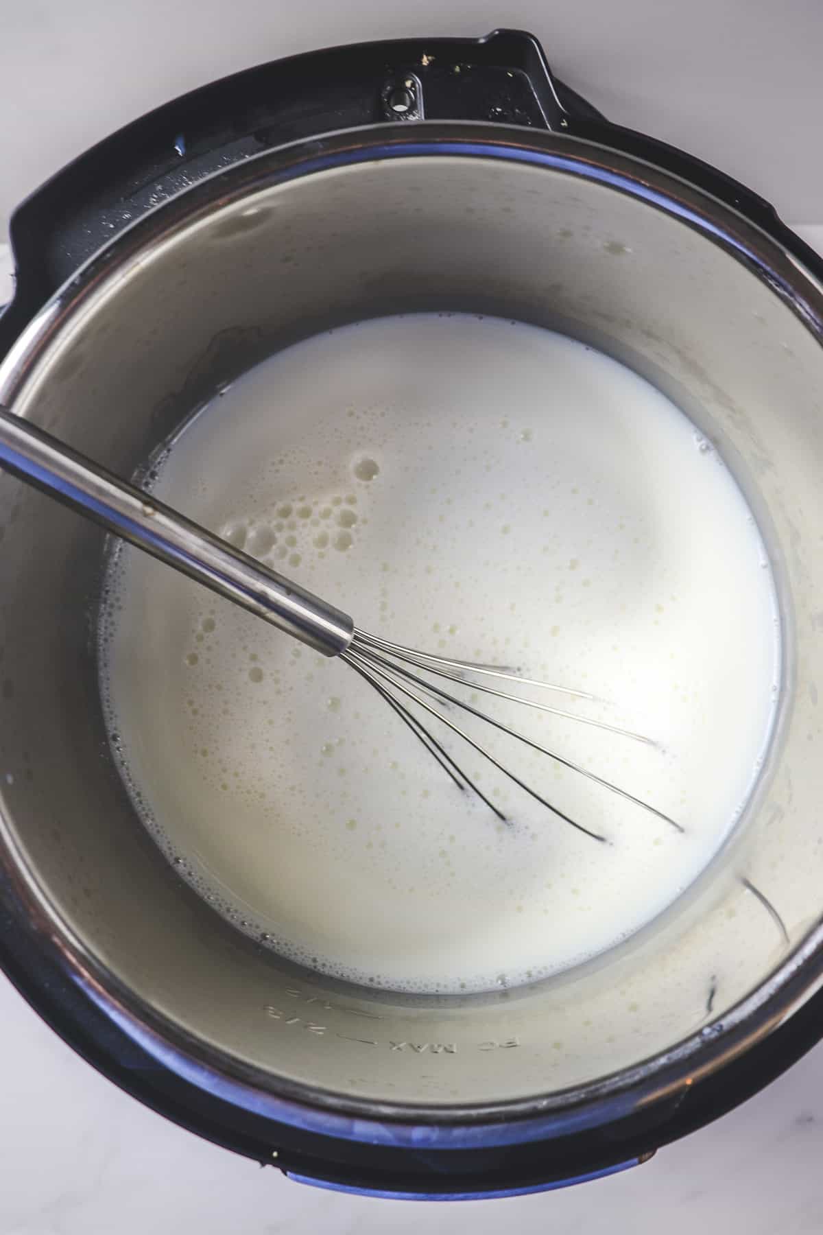 whisking the yogurt starter into the milk in the instant pot