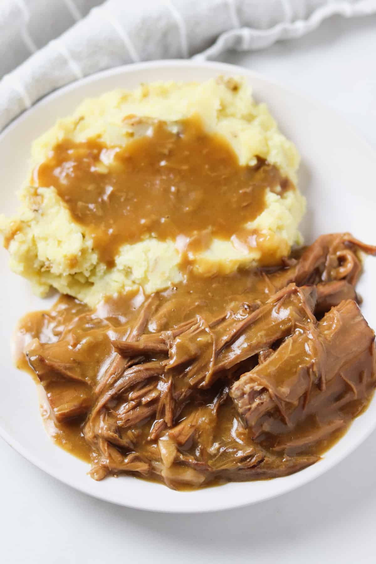 plate with pot roast with gravy and mashed potatoes with gravy