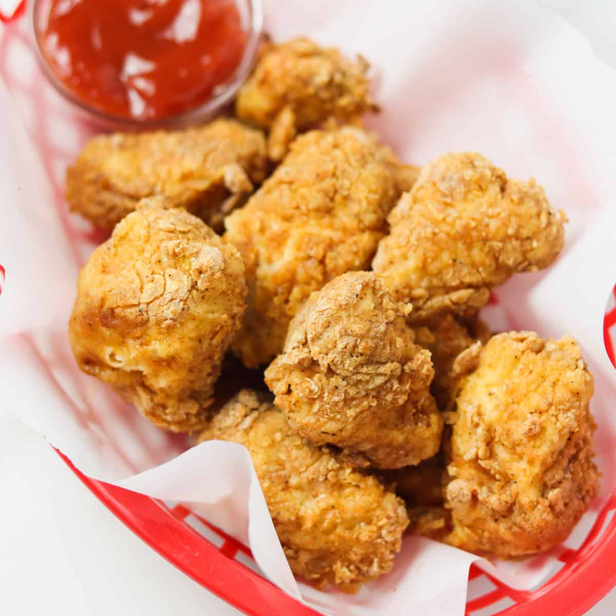 air fryer chicken nuggets in red plastic basket