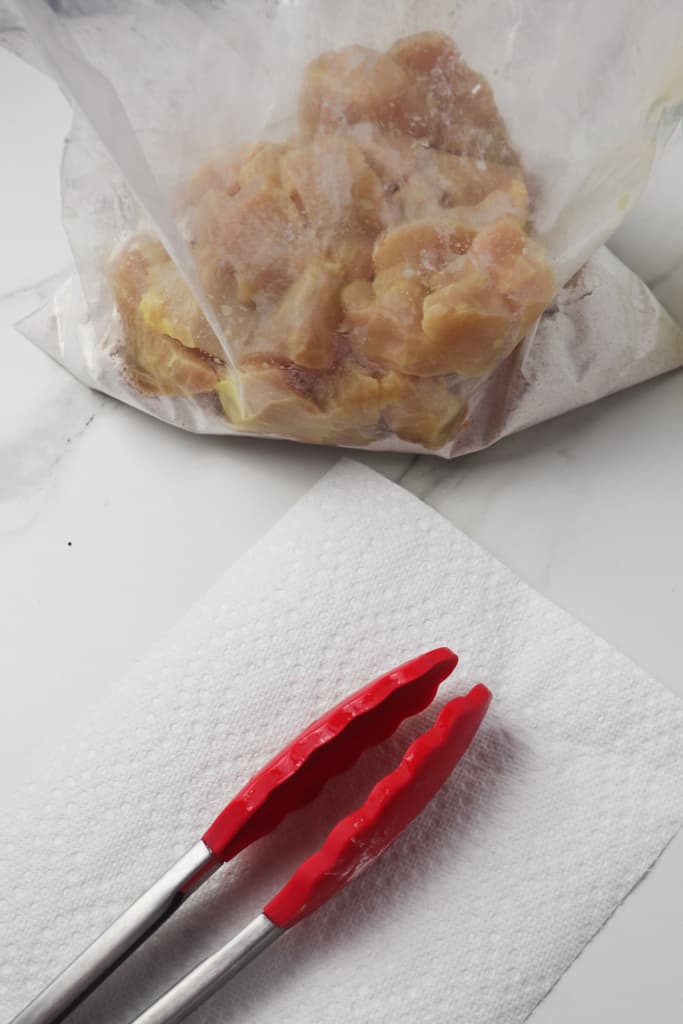 loading chicken nuggets in gallon sized bag with flour mixture