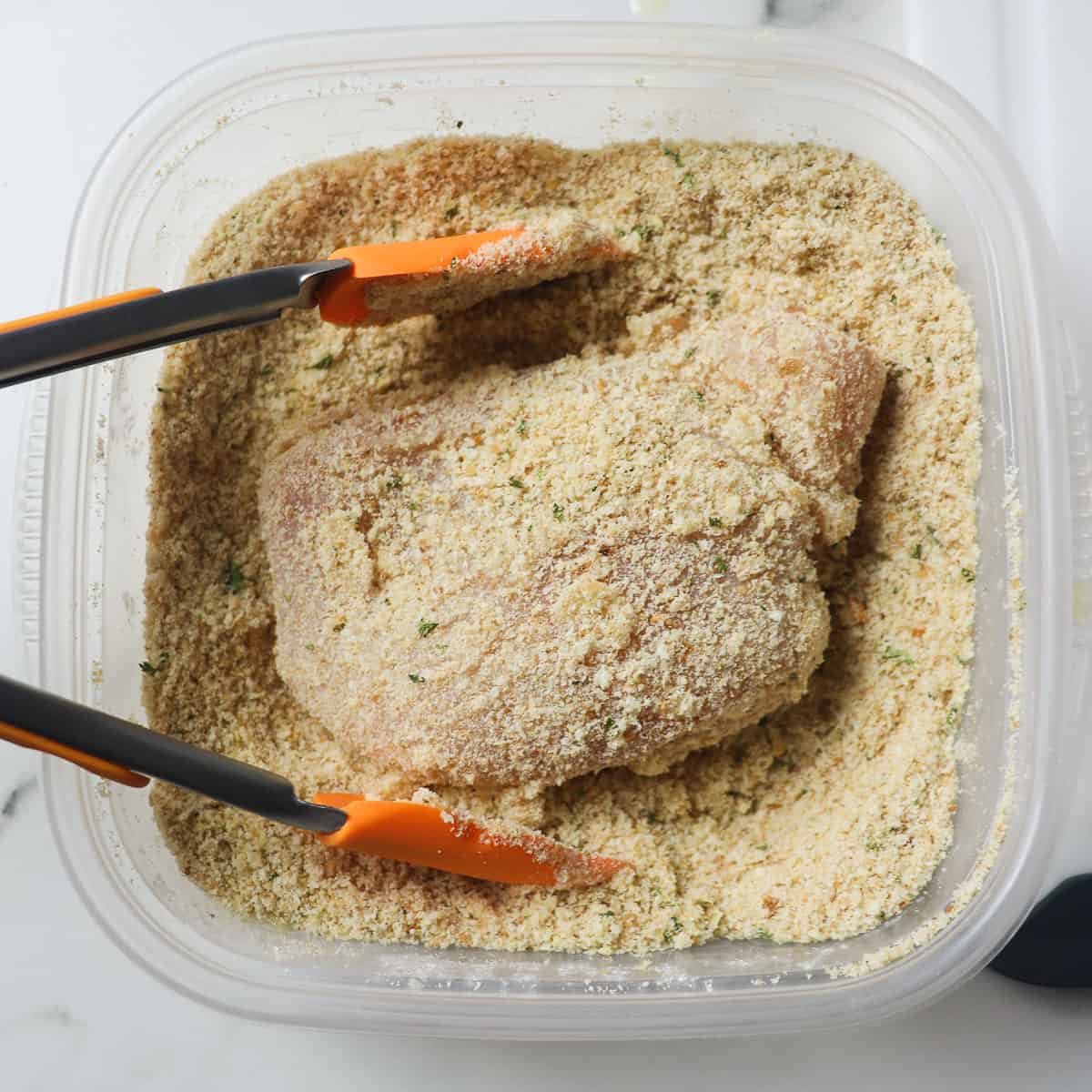 dipping chicken breasts into breadcrumb mixture