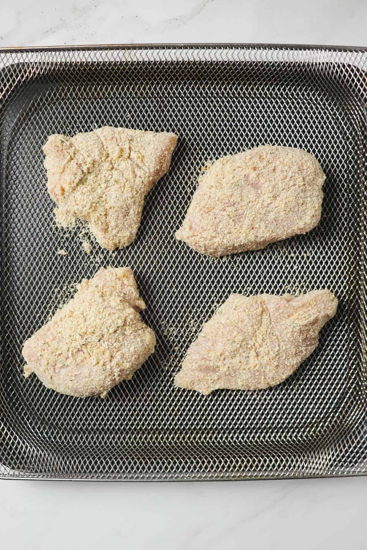 breaded chicken breasts in air fryer basket