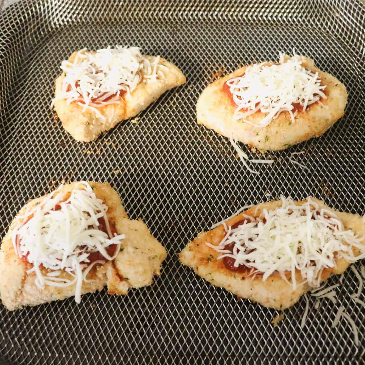 adding marinara and mozzarella to air fryer chicken parmesan