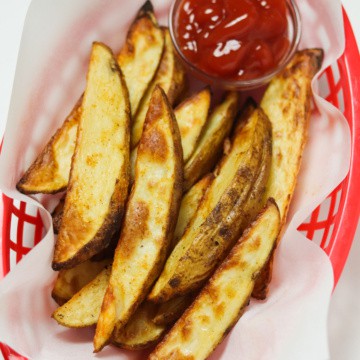 air fryer potato wedges with ketchup in basket