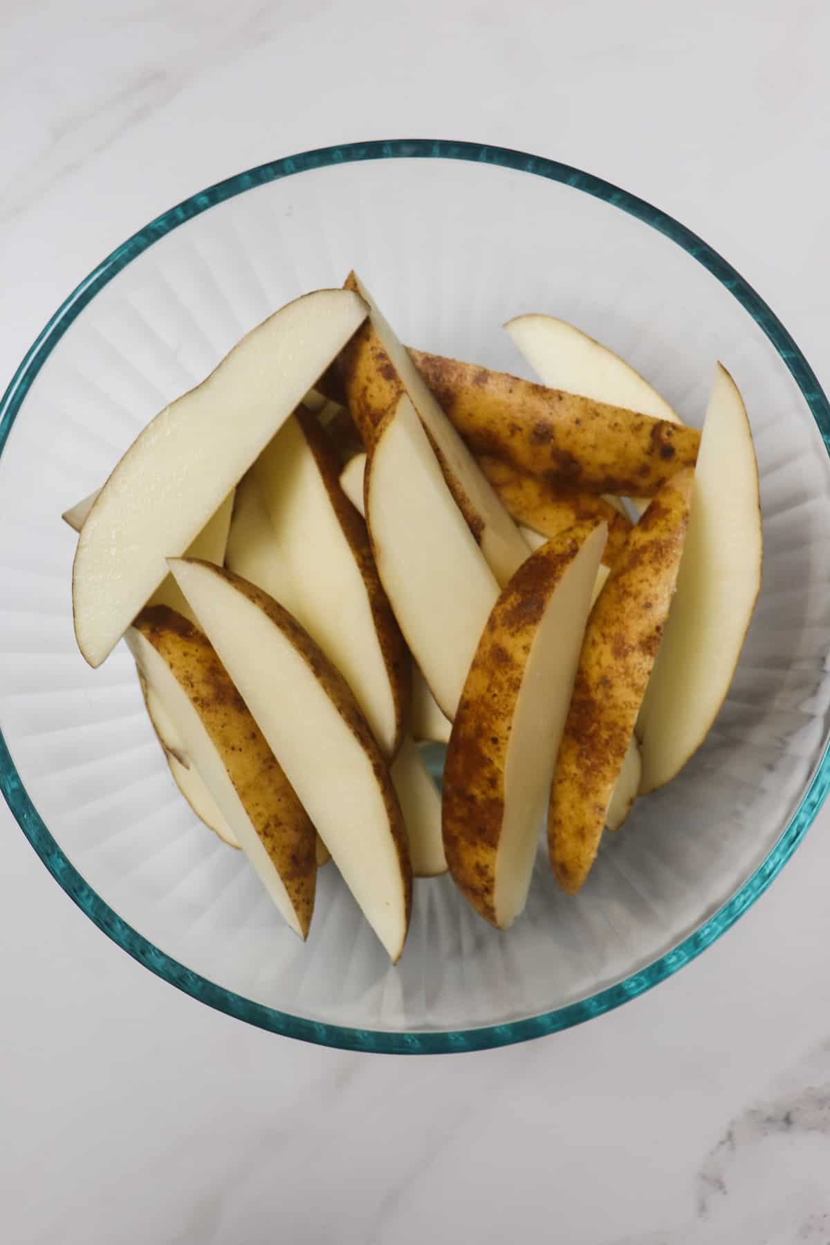 cut potato wedges in a glass bowl