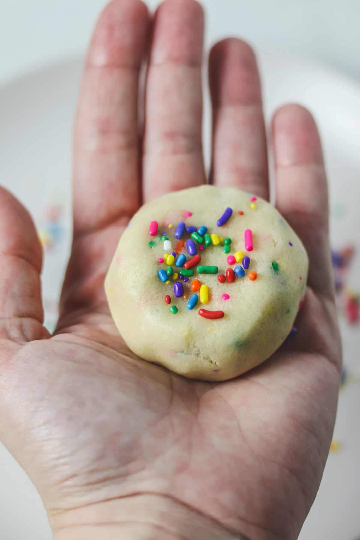 holding a piece of edible sugar cookie dough in hand