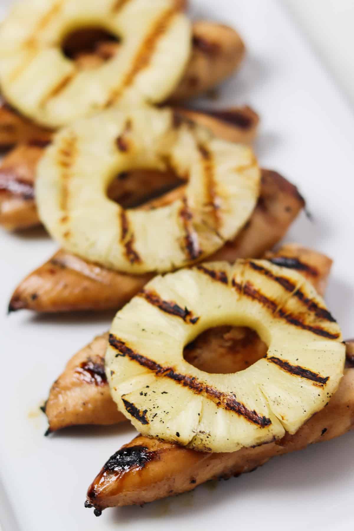 grilled chicken tenders with grilled pineapple rings on top