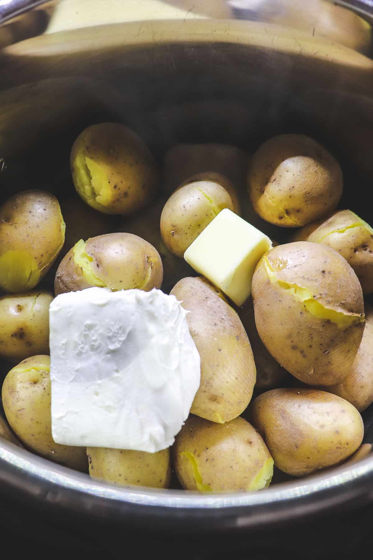 adding cream cheese and butter to cooked potatoes in the instant pot