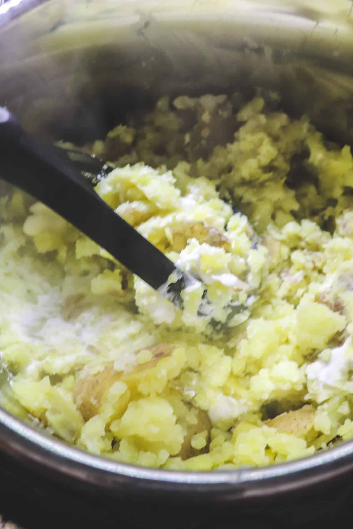 mashing potatoes, cream cheese, and butter in the instant pot