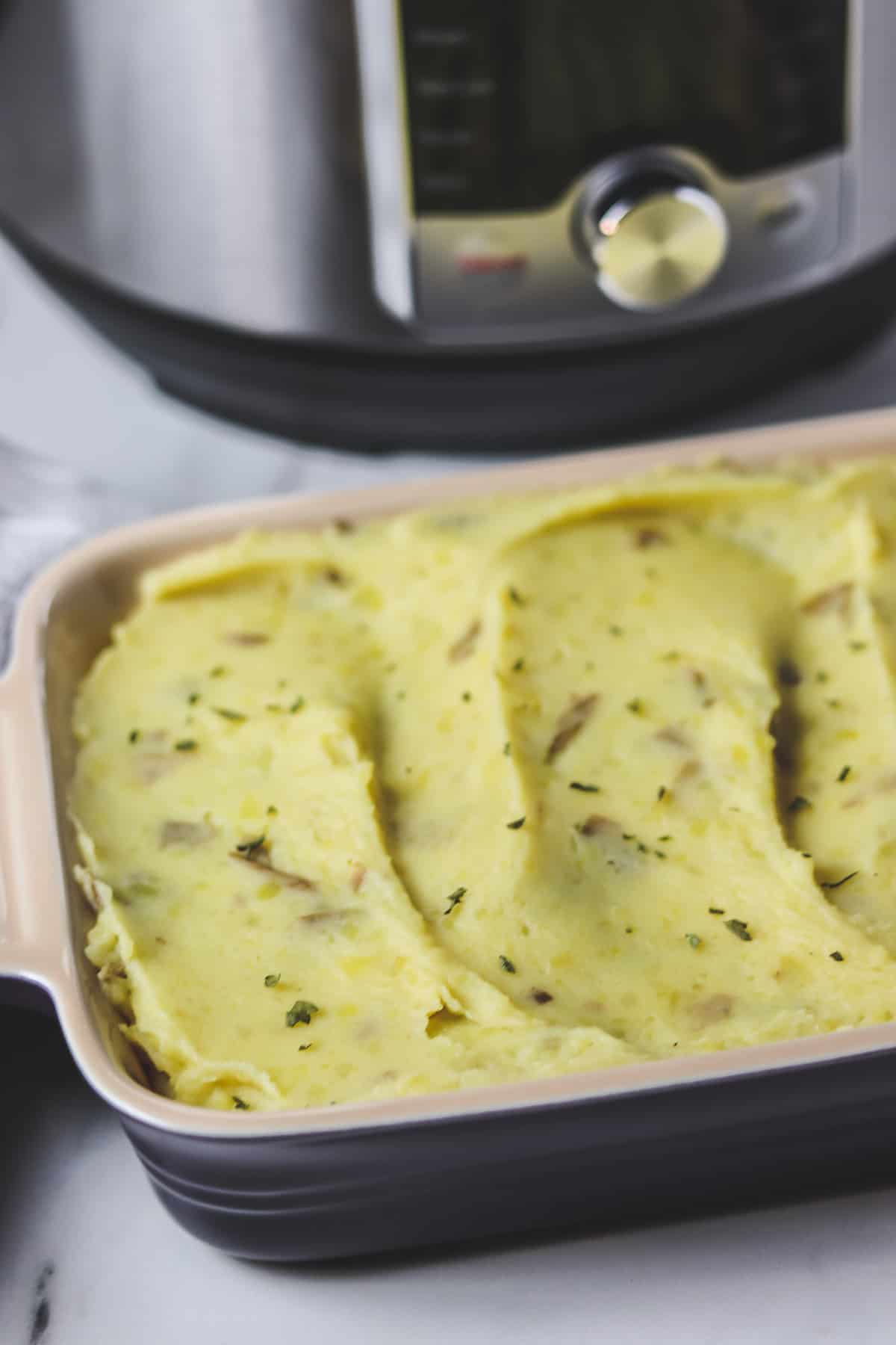 casserole dish of mashed potatoes in front of instant pot