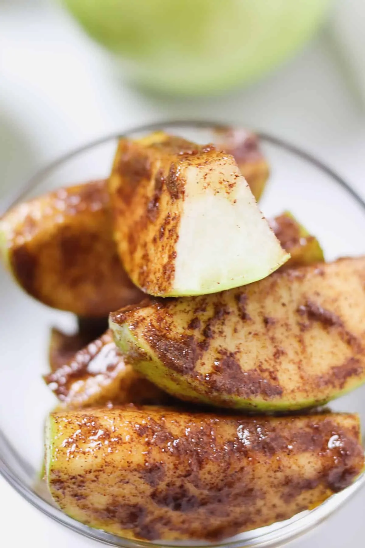 bowl of cinnamon sugar apple slices with a bite taken out