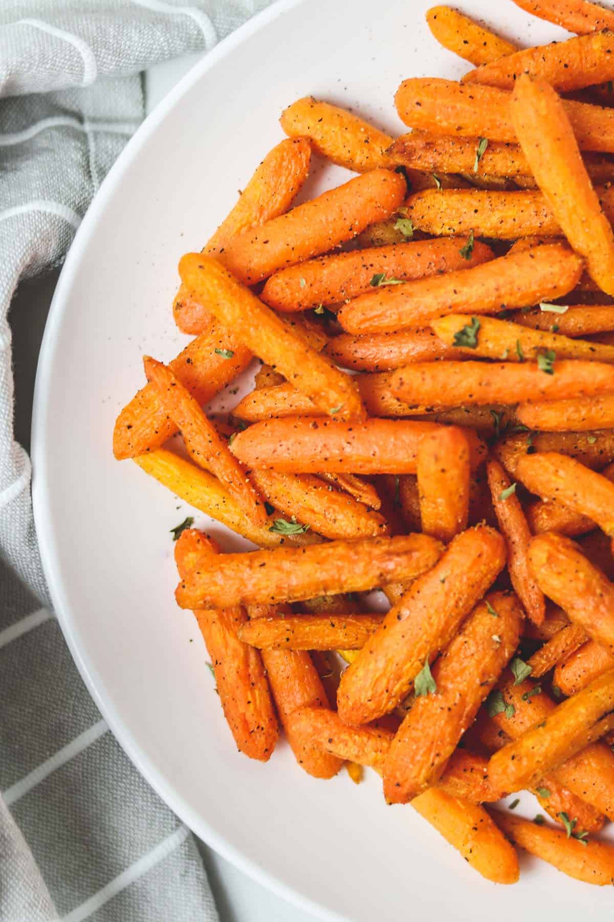 roasted baby carrots on a white plate