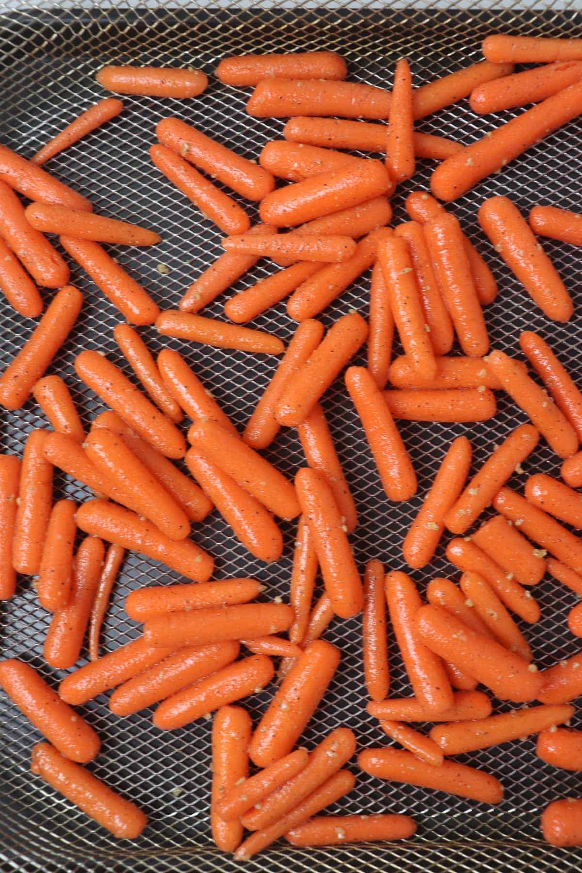 uncooked baby carrots in air fryer basket