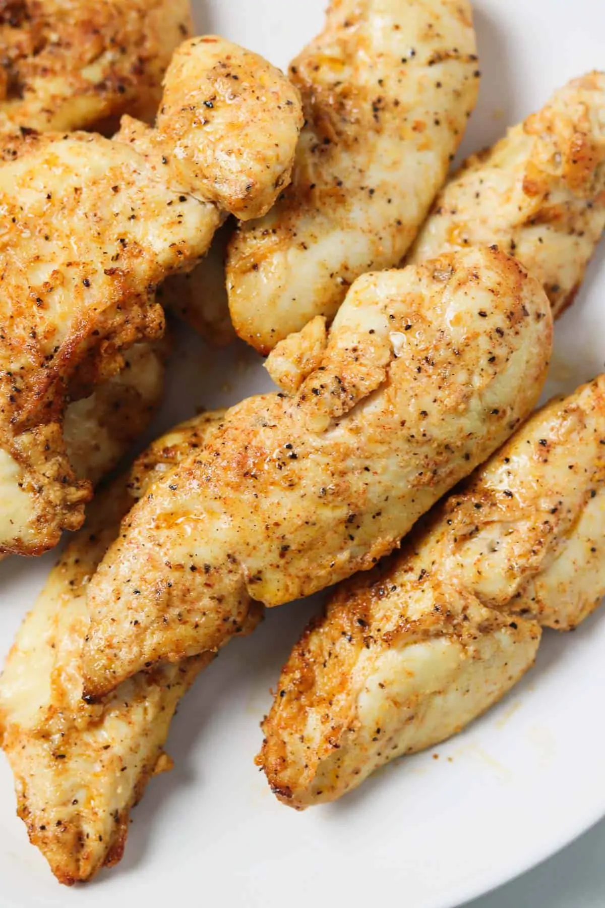 air fried naked chicken tenders piled on plate