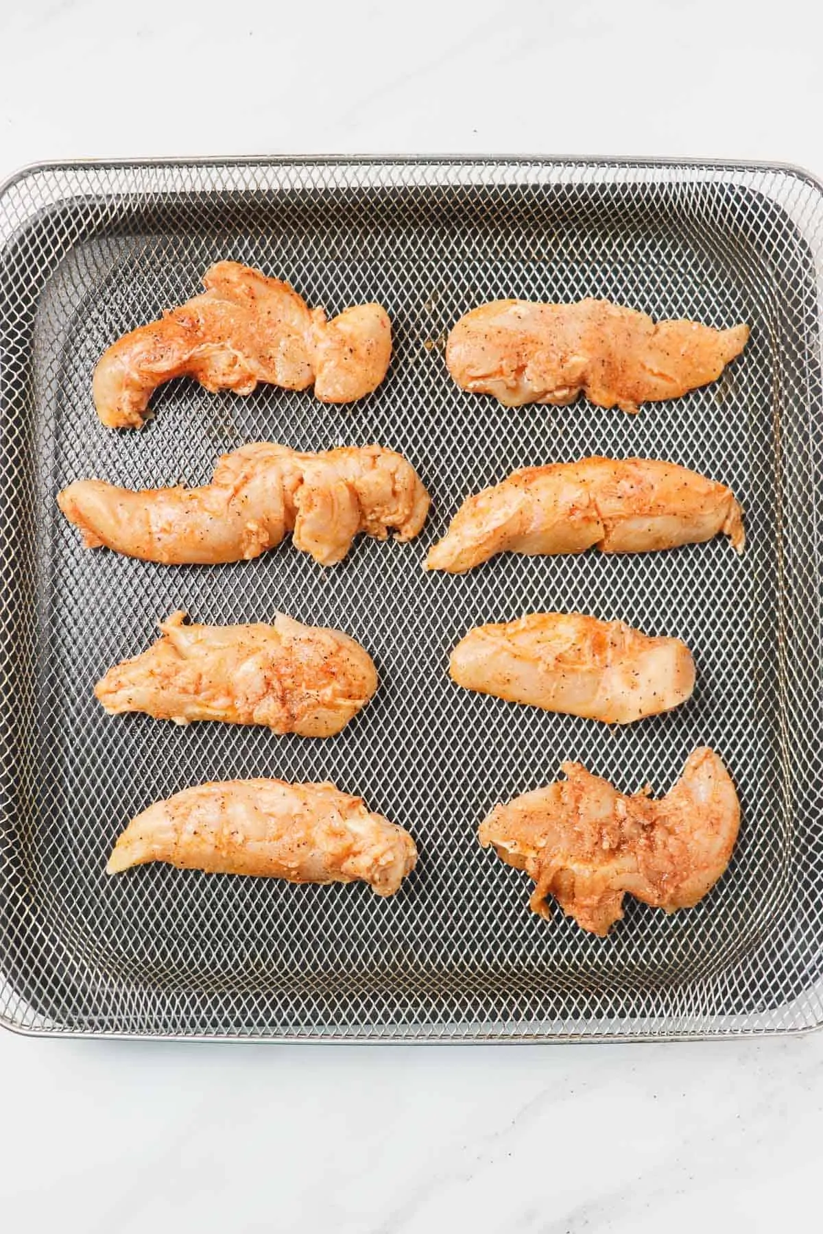 raw chicken tenders in air fryer basket