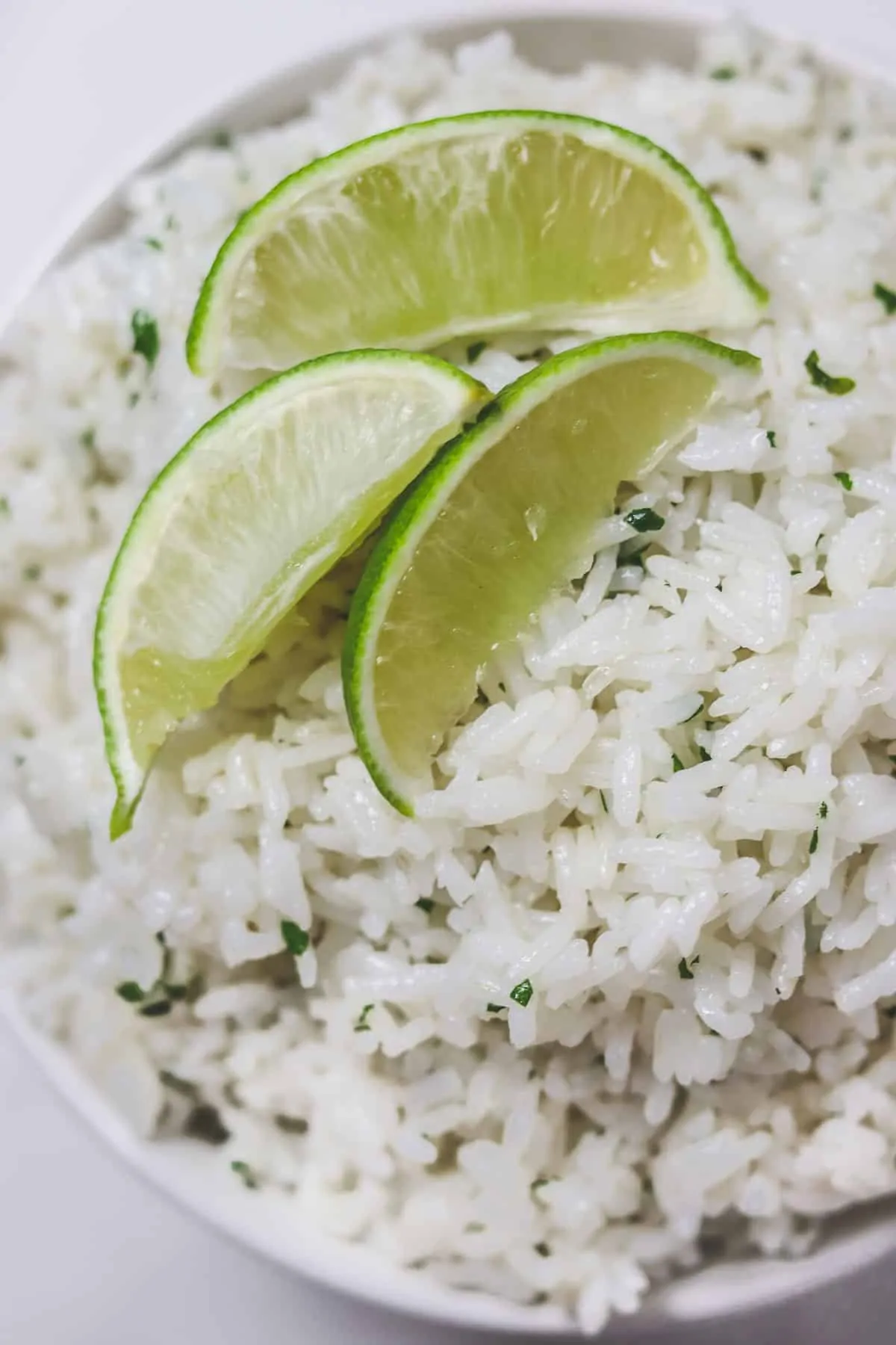 bowl of cilantro lime rice with lime wedges on top