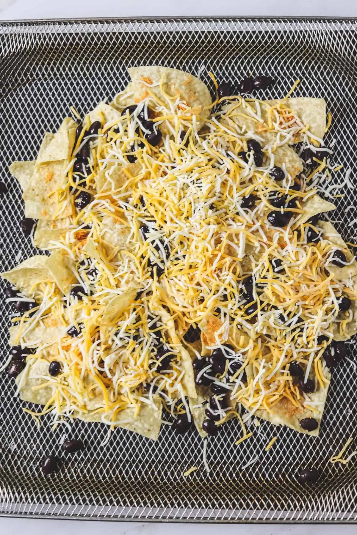 uncooked nachos in the air fryer basket