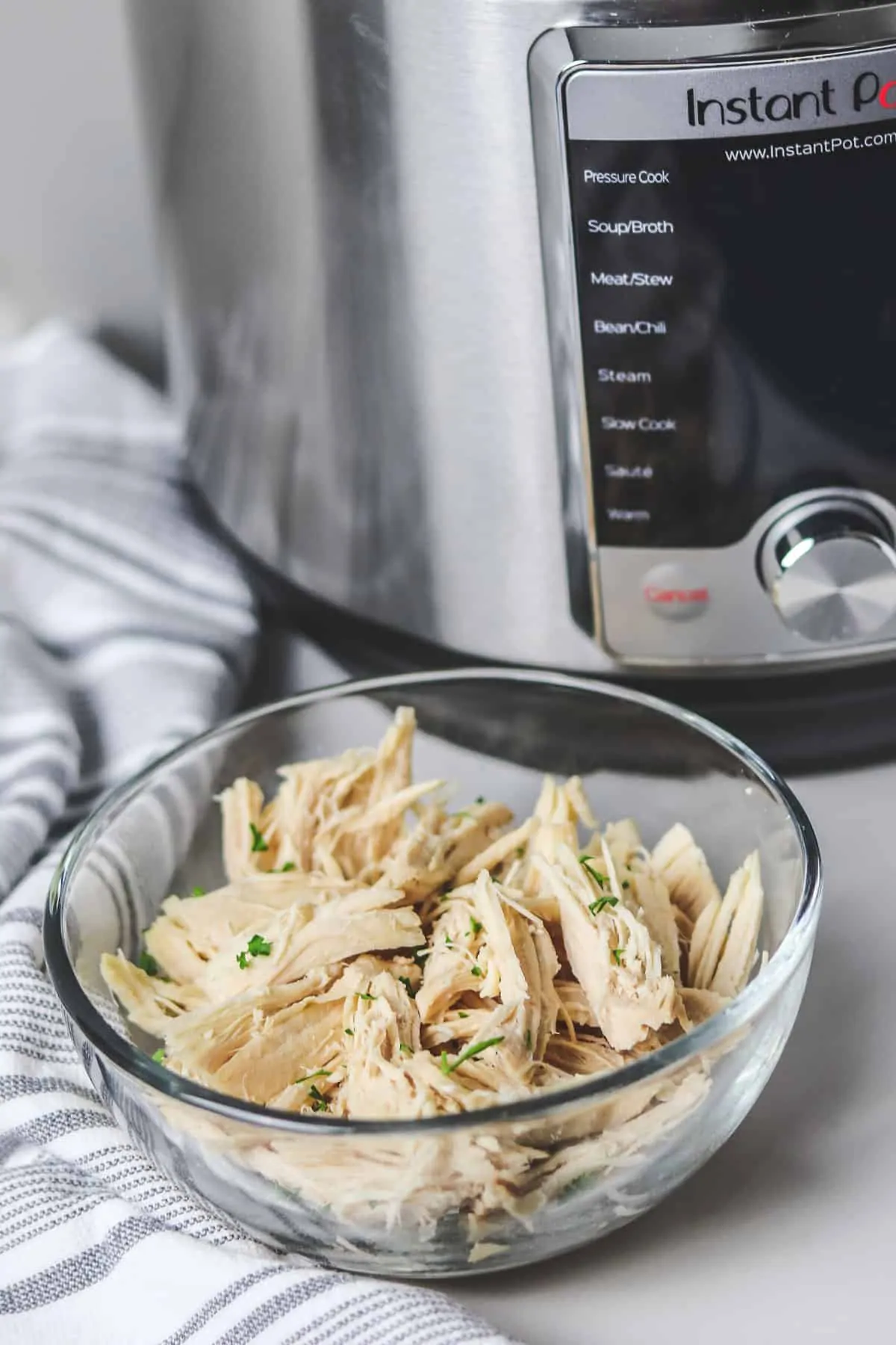 bowl of shredded chicken in front of the instant pot