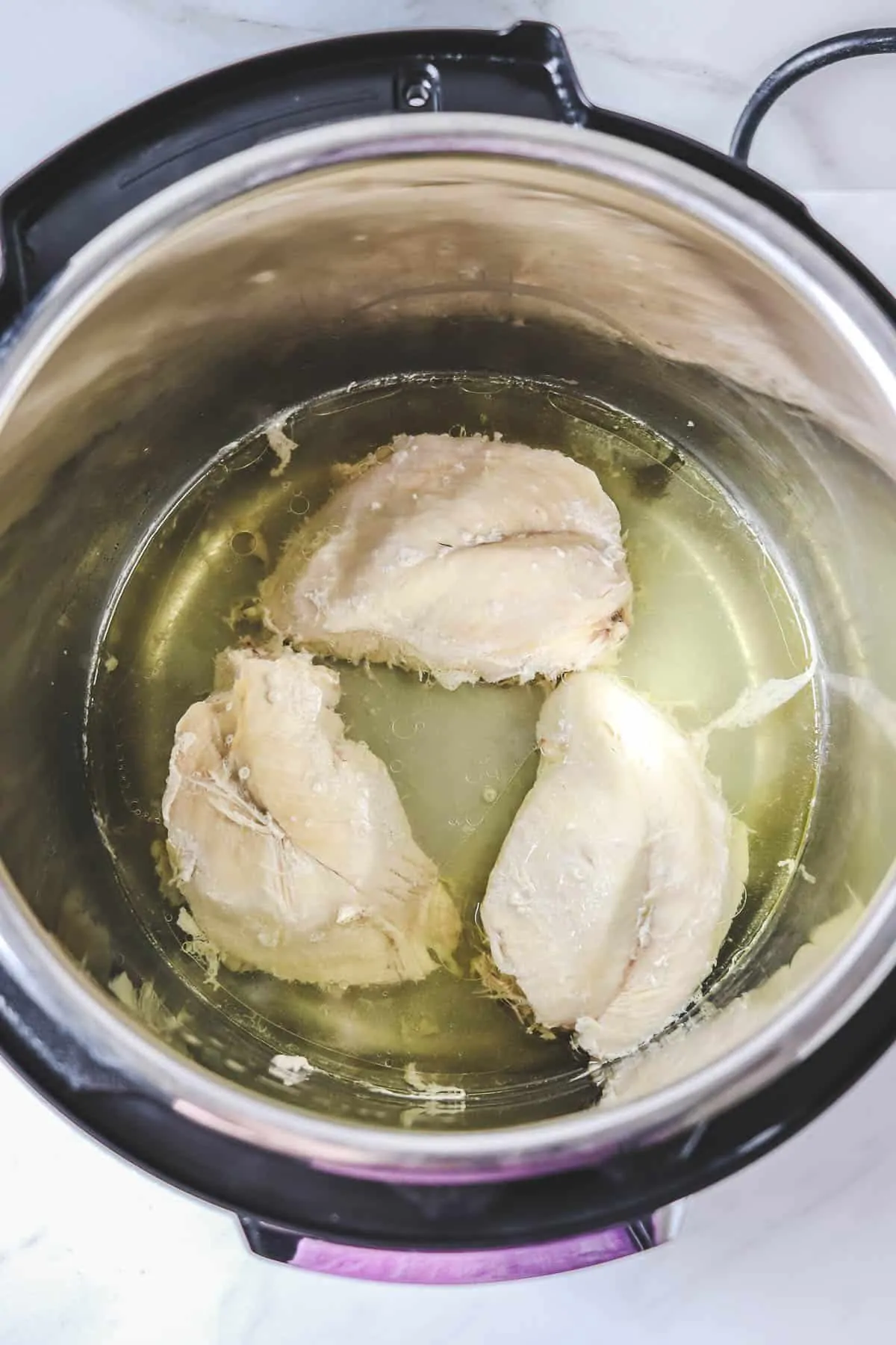 cooked chicken breasts in broth in the instant pot