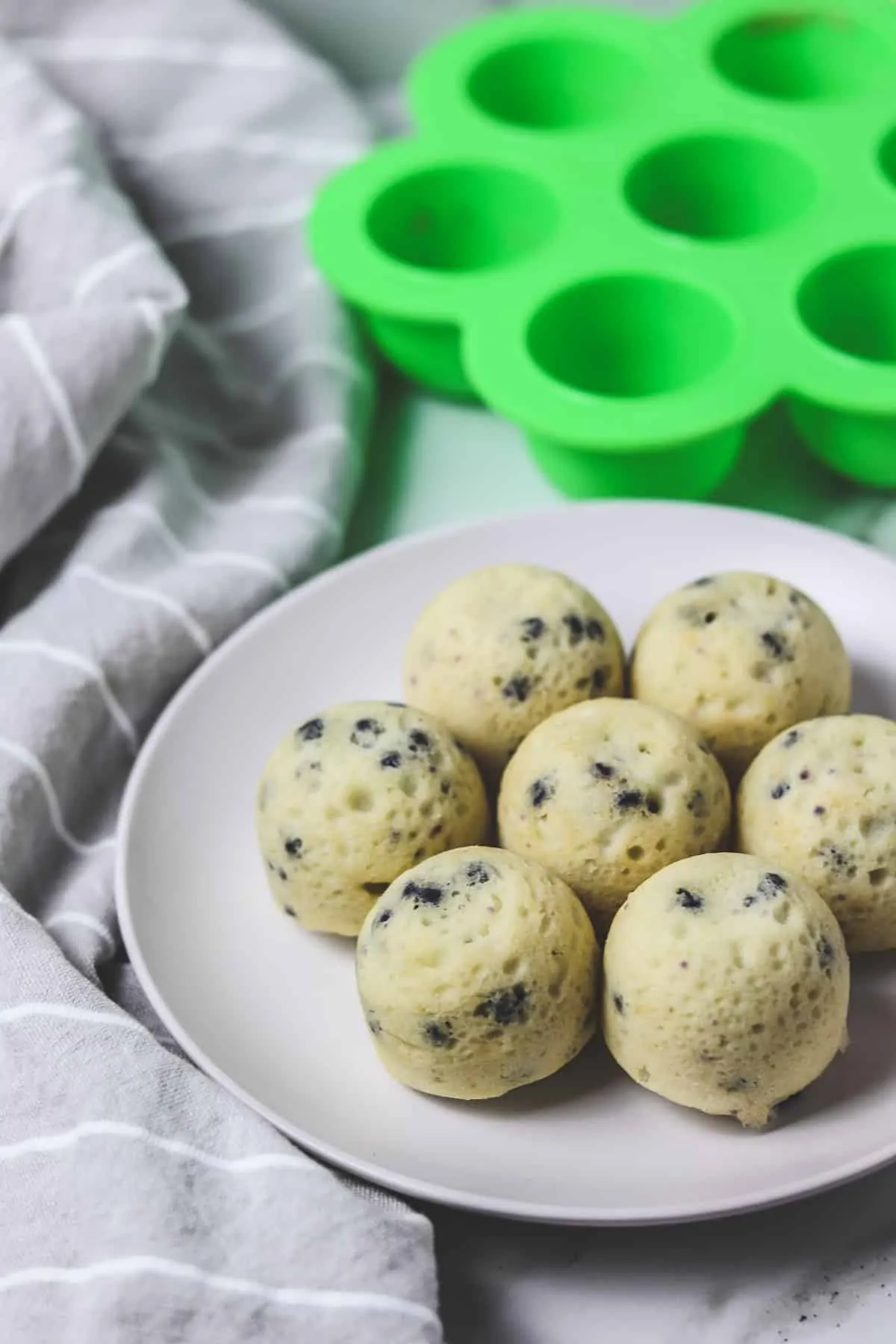 muffin bites on a plate with the egg bites mold in the background