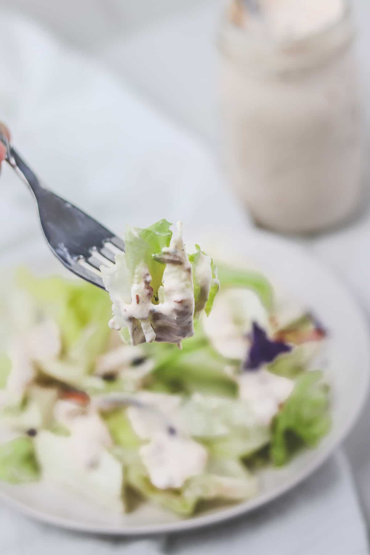 taking a bite of salad topped with with salsa ranch dressing