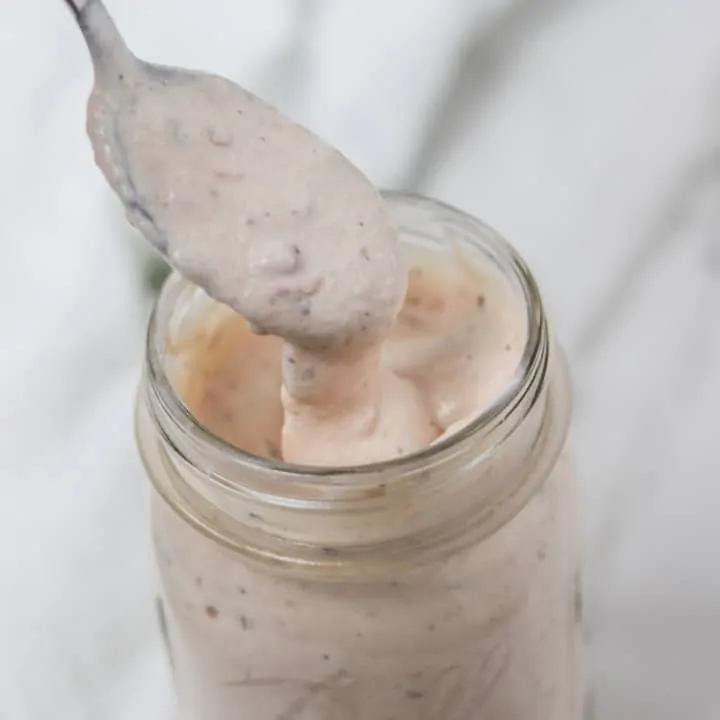 scooping a spoonful of salsa ranch dressing from a mason jar