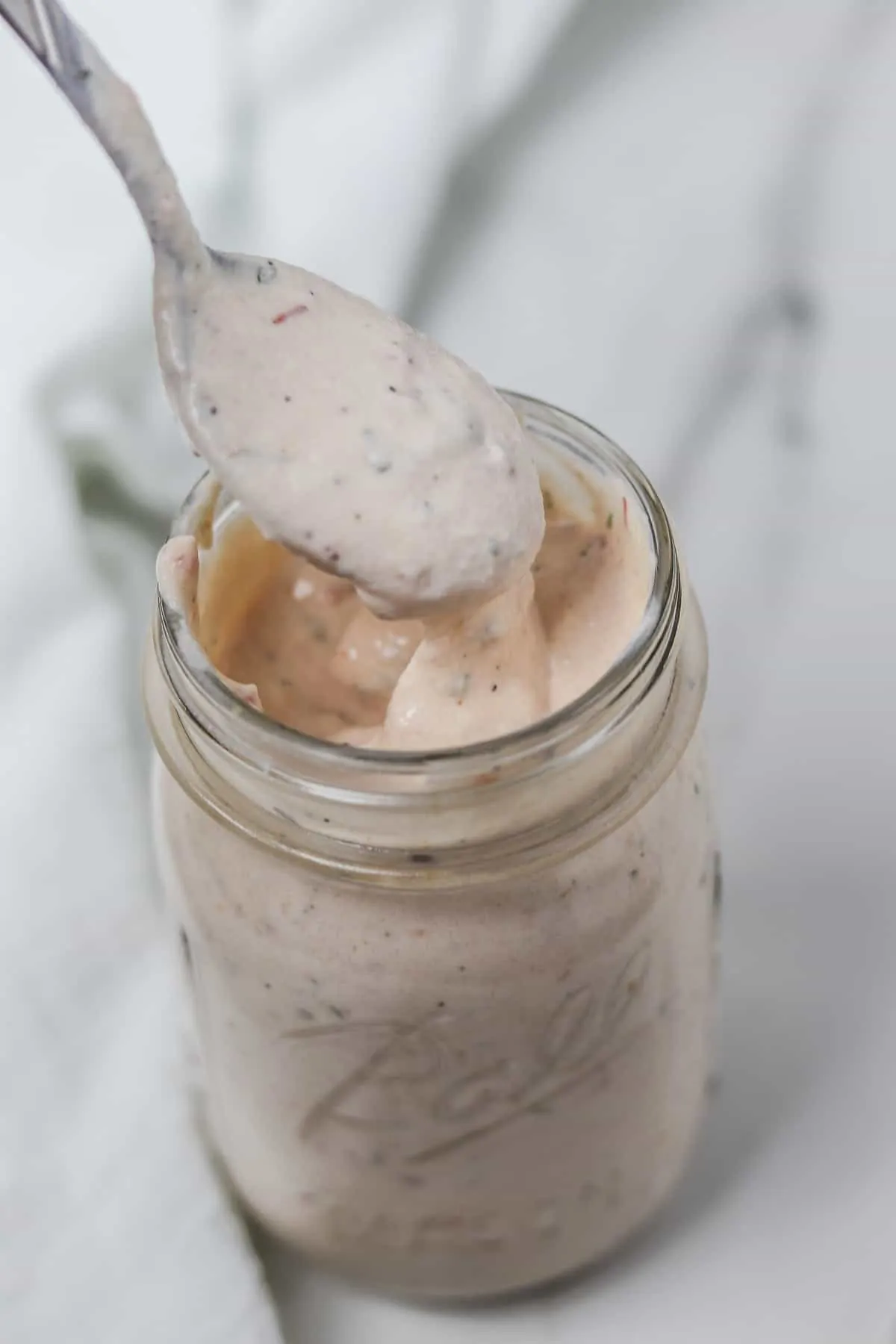 scooping a spoonful of salsa ranch dressing from a mason jar