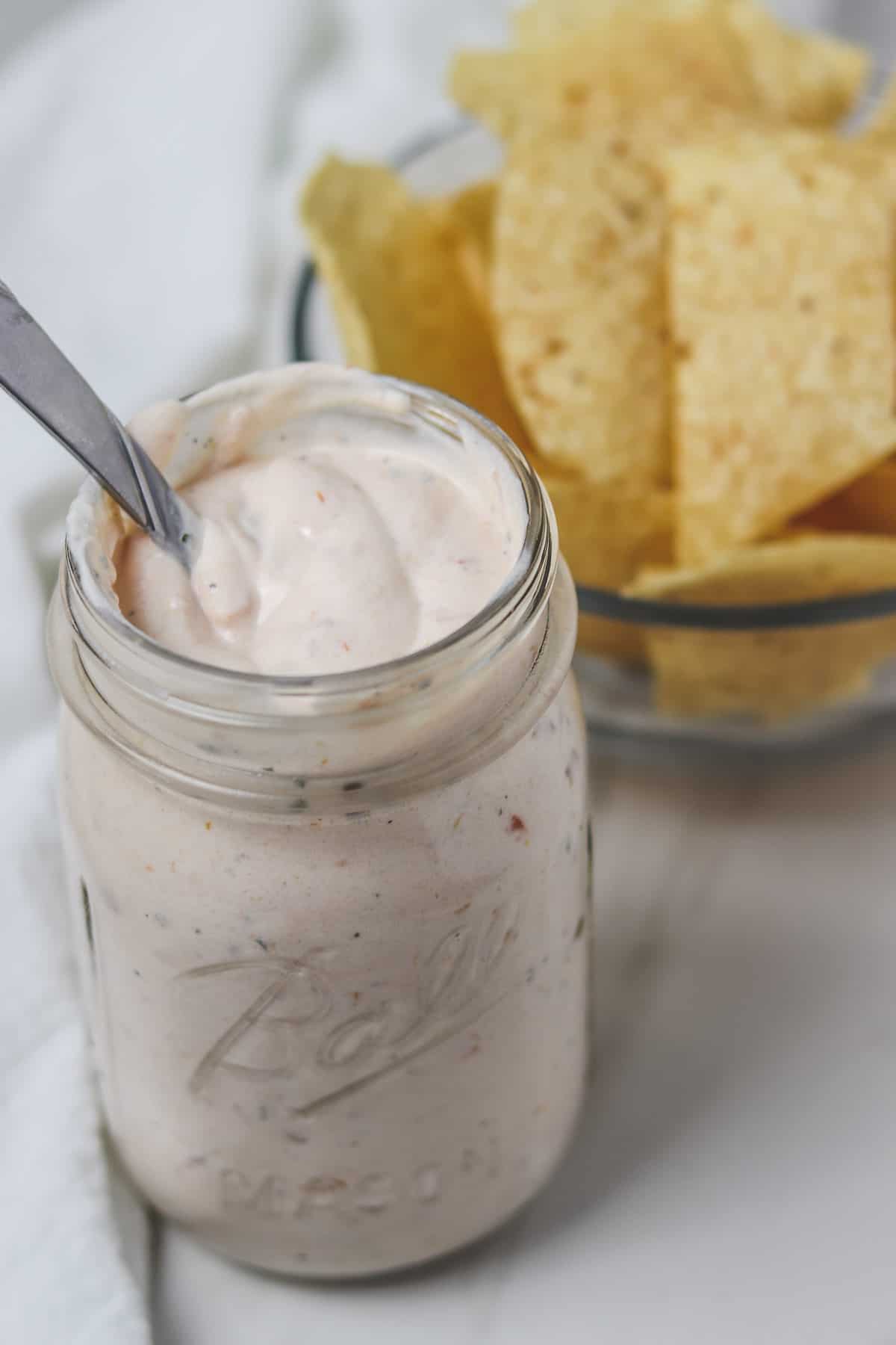 salsa ranch dressing in a mason jar with tortilla chips in the background