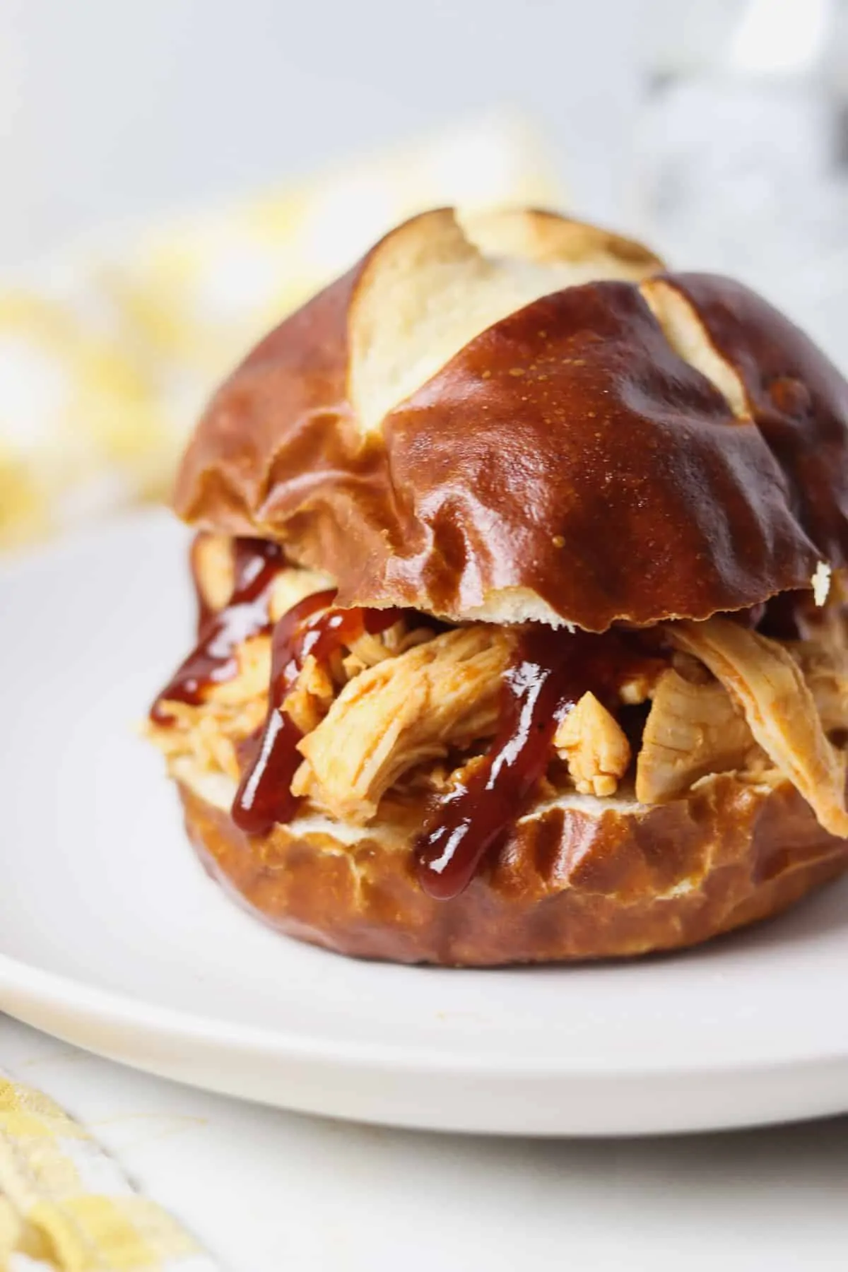 shredded bbq chicken on a pretzel bun