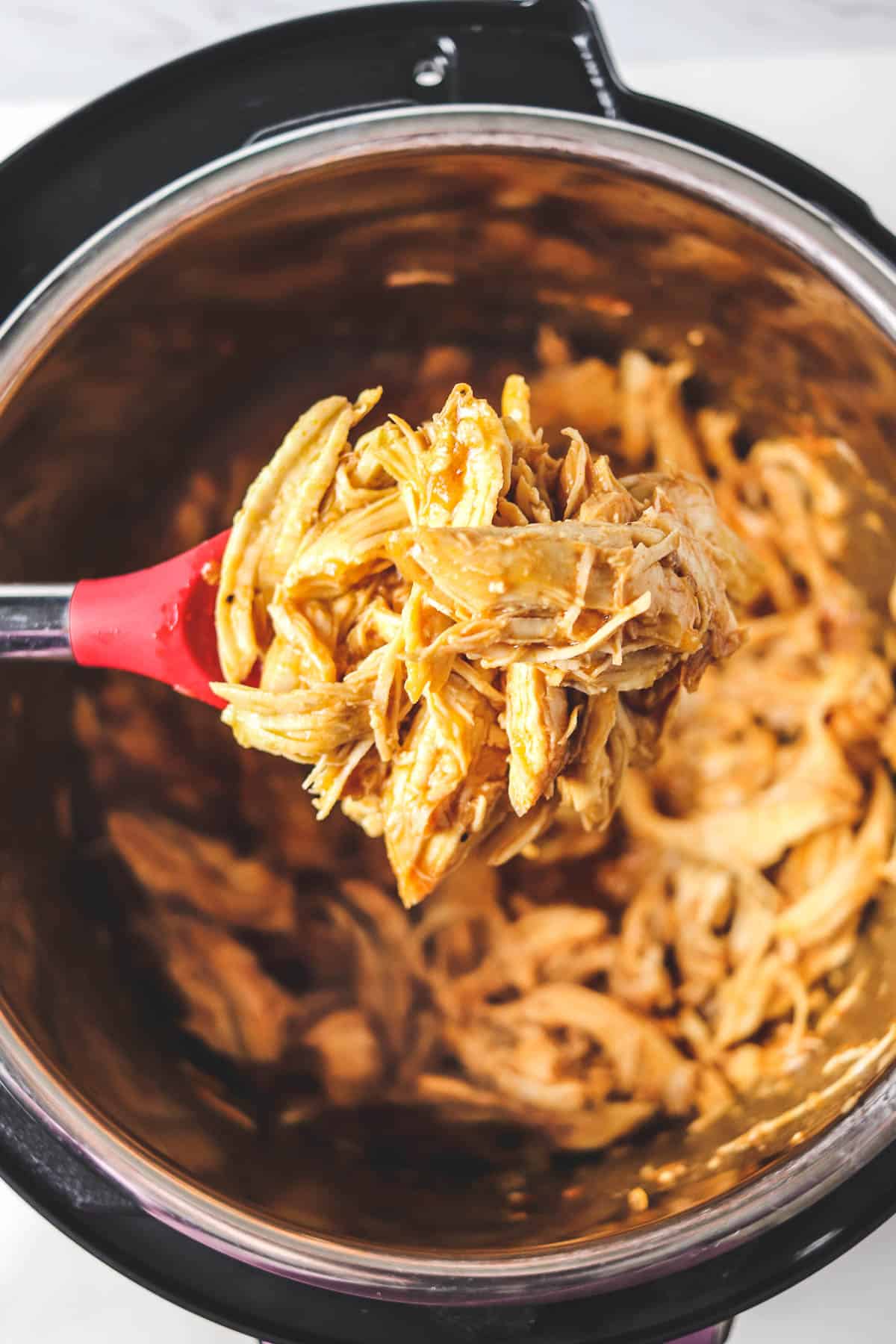 instant pot bbq chicken being served with a spoon