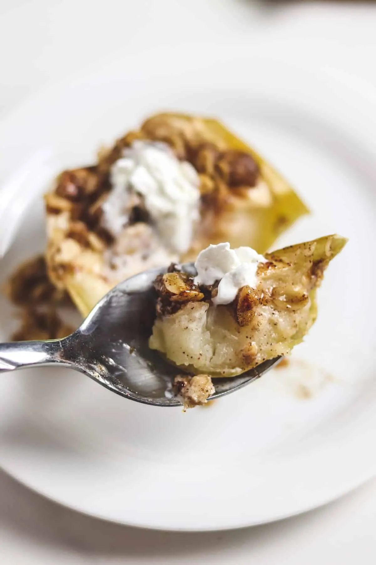 taking a bite of baked apple with a spoon