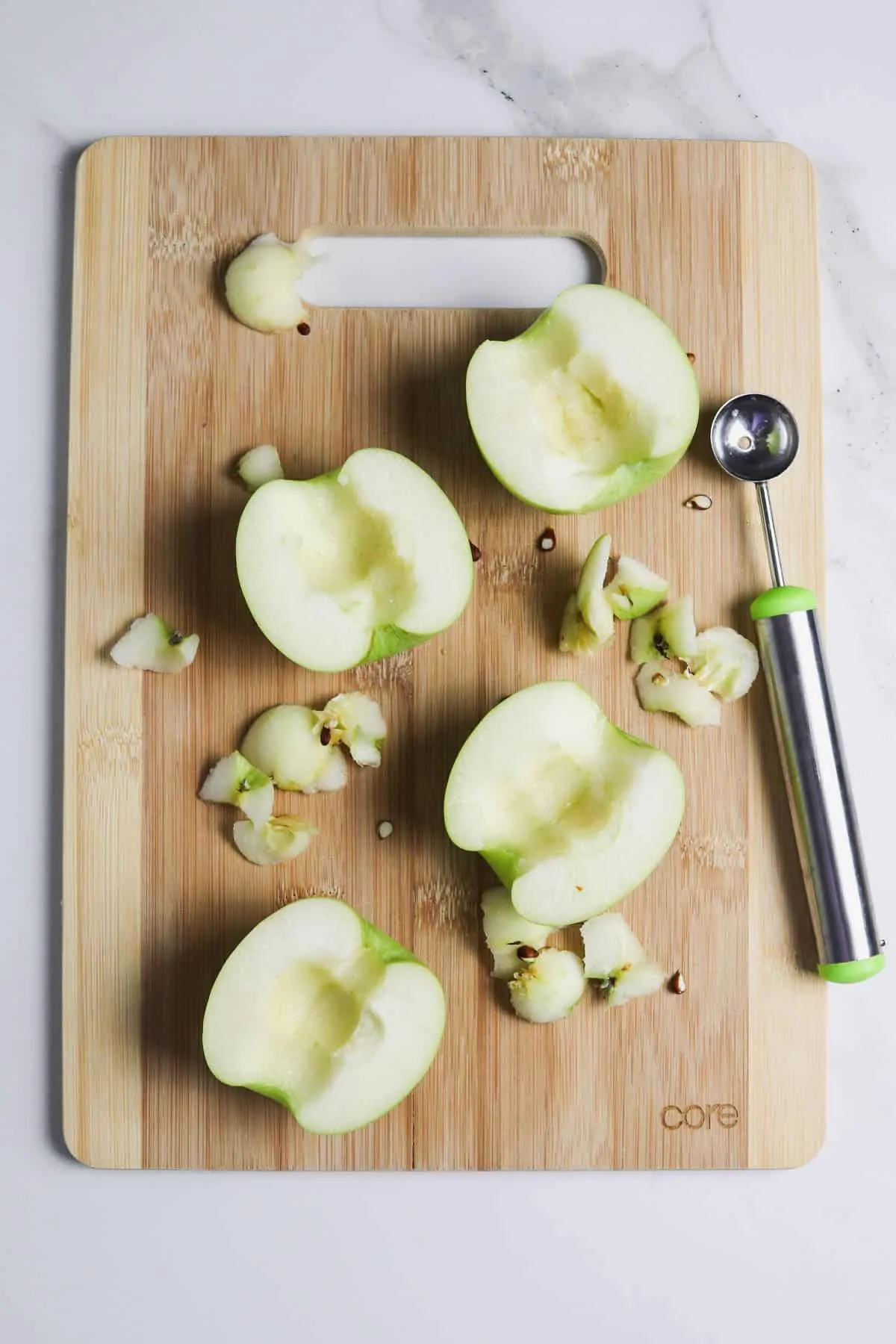 scooping out the apple cores on a cutting board