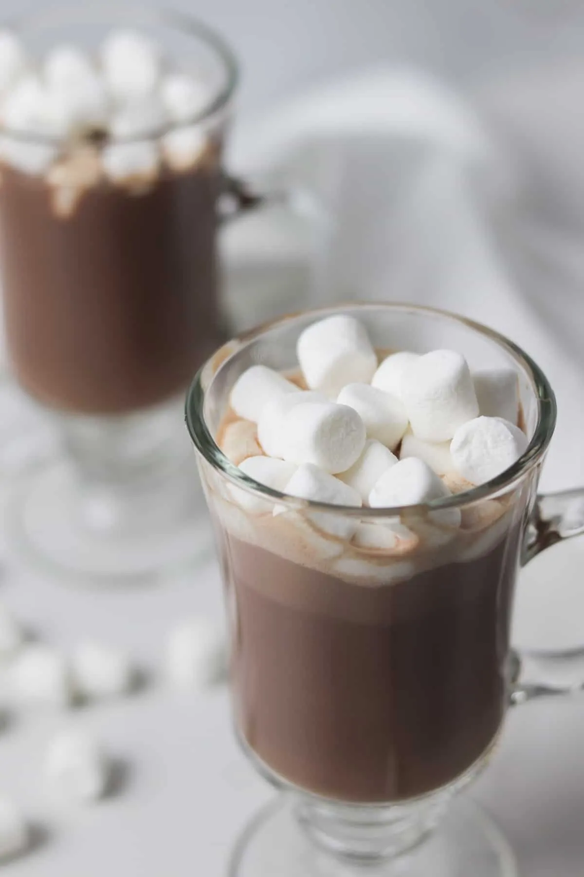 two glasses of hot chocolate topped with marshmallows