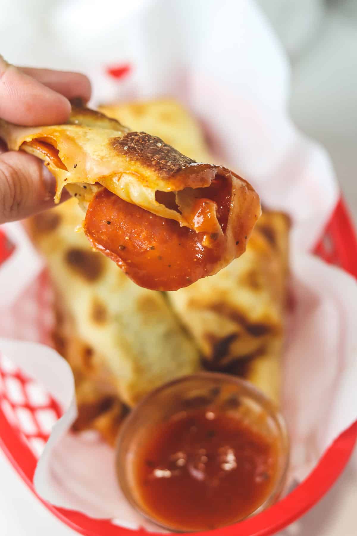 dipping an air fryer pizza roll in sauce